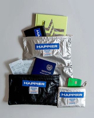 Assorted zip pouches in silver, black, and lime green with HAPPIER labels