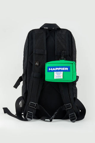 Green Happier label tofu pouch attached to a black backpack