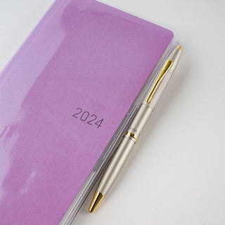 Purple planner cover with “2024” and matching pen beside it