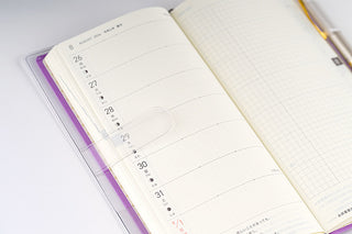 Clear planner cover open to monthly view pages with printed dates and lines