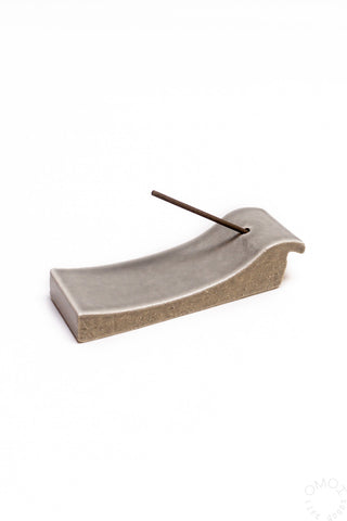 Grey ceramic incense burner with curved channel and standing incense stick
