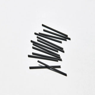 Black incense sticks arranged in a loose bundle