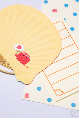 Beige uchiwa fan greeting card close-up with orange grid lines and fish