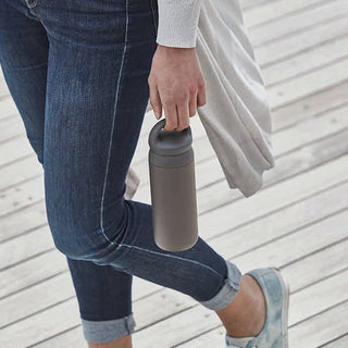 Dark gray 500ml tumbler held outdoors with lid and carry loop handle