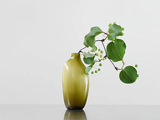Olive green glass vase with narrow neck and rounded body, with flowers