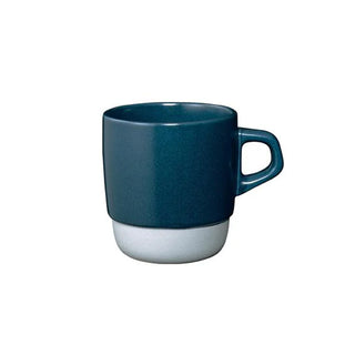 Ceramic coffee mug with dark teal body, white base, and side handle