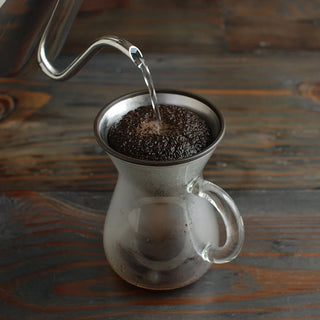 Coffee carafe with clear glass body, stainless pour spout, side handle, brewed coffee