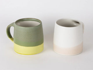 Two-tone mugs: moss green with yellow band, plus a white mug with dark band