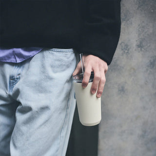 White 480 ml insulated tumbler with straw, held with metal straw visible
