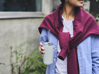 White 480 ml insulated tumbler with clear lid and straw, held upright