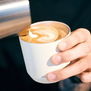 KINTO TO GO tumbler with plug and clear lid, held in hand
