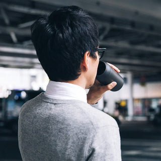 Gray 500ml travel tumbler in use for drinking with black lid