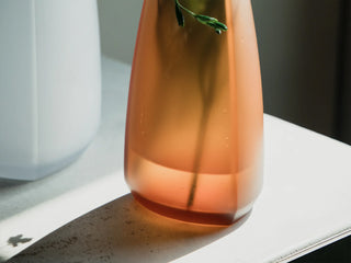 KINTO TRE amber glass vase close-up with smooth flared opening and curved sides.