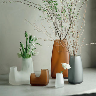 KINTO TRE glass vases in amber and smoke colors, each holding or ready for flowers.