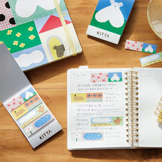 Assorted washi tape rolls and card with animal-themed designs; used on notebook