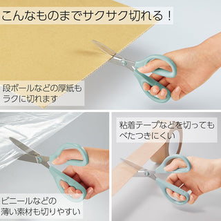 Teal nonstick scissors in hand cutting paper strips with tape