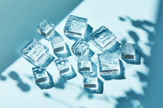 Multiple clear stamp blocks with engraved motifs arranged on a blue surface
