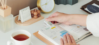 Mini clip sticky notes with pastel tabs on an open planner