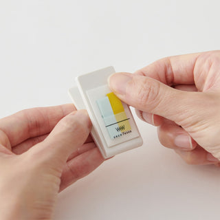Hands holding mini clip sticky notes with misty mint blue and yellow pads