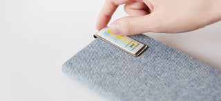 Pastel sticky notes being placed on a fabric-covered notebook cover
