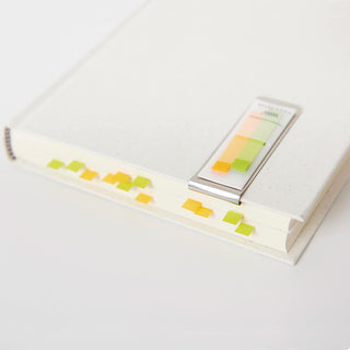 Pastel sticky note flags on a notebook with a small sticky note pad