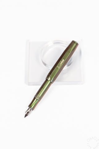 Shadow green fountain pen with medium nib, angled on clear display case