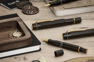 Kaweco piston fountain pen, black body with gold trim; one nib visible