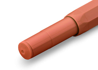 Coral orange rollerball pen with cap end, close-up view of barrel