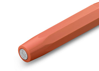 Coral orange rollerball pen with round end and seal detail, close-up