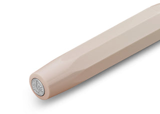 Light cream rollerball pen with circular emblem at tip end, close-up
