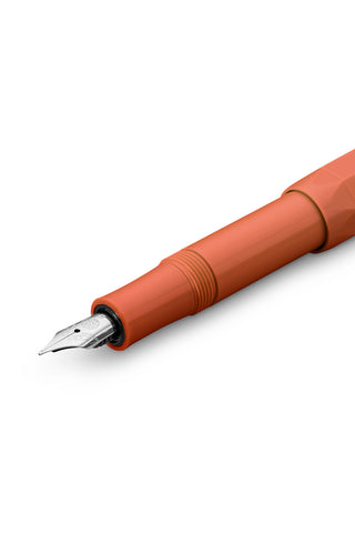 Orange fountain pen close-up with medium nib and black grip ring