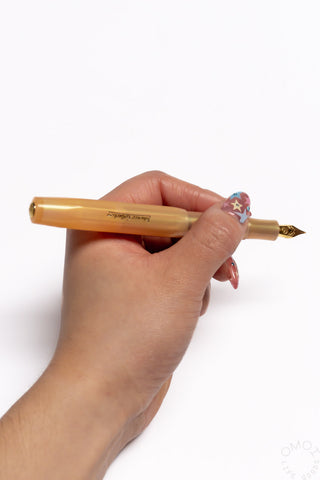 Apricot Kaweco Collection Sport fountain pen with gold nib held in hand