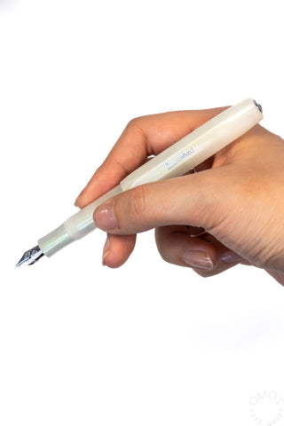 Light green fountain pen held in hand, fine nib tip visible