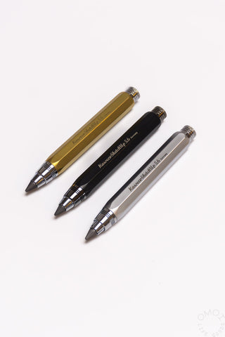 Three clutch pencils in brass, black, and silver with knurled grip rings