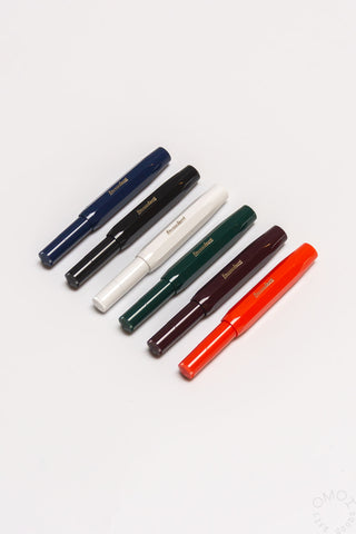 Six rollerball pens arranged together in navy, black, white, green, bordeaux, red