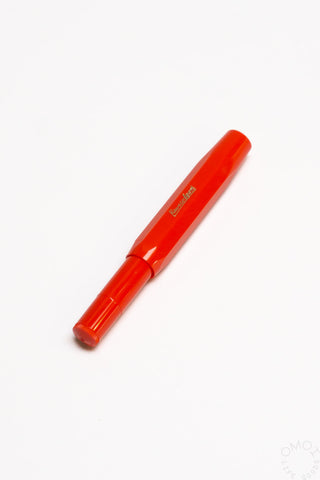 Red rollerball pen with capped tip and gold logo