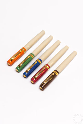 Four student fountain pens with medium nibs, beige bodies with orange, green, blue, and red barrels