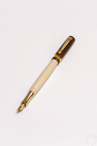 Cream fountain pen with gold nib, clip, and cap band