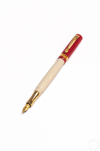 Red student fountain pen with medium nib, beige grip section and gold nib tip
