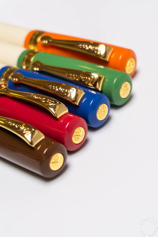 Close-up of colored fountain pens with gold nibs and clips