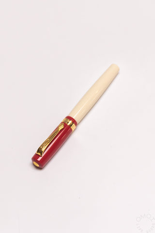 Student rollerball pen with beige barrel, red band, and gold clip and tip