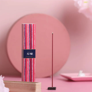 Striped pomegranate incense bundle with upright stick on dark base stand