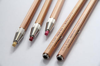 Close-up of wooden 3.3mm lead holders with metal tips and visible markings