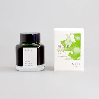 Black glass ink bottle with green watercolor label and white presentation box.