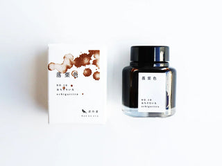 Glass ink bottle with black cap and dark amber ink, with matching ink box