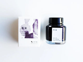 Glass ink bottle with black cap and light purple ink, with matching ink box