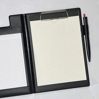 A5 field pad in black, close-up open with grid paper and pen