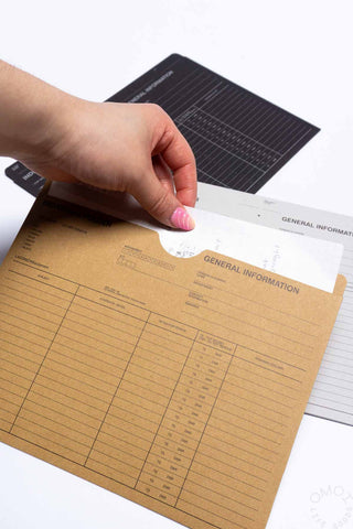 Brown A5 individual folder with printed grid and General Information section, held by a hand