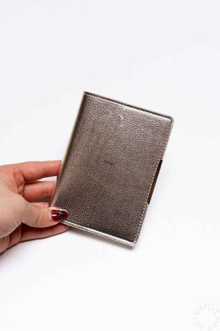 Silver textured pocket log diary held in hand, flat front cover with stitched border