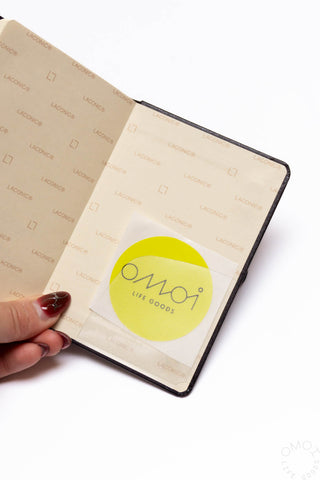 Close-up of beige diary insert with OMO goods logo and icons